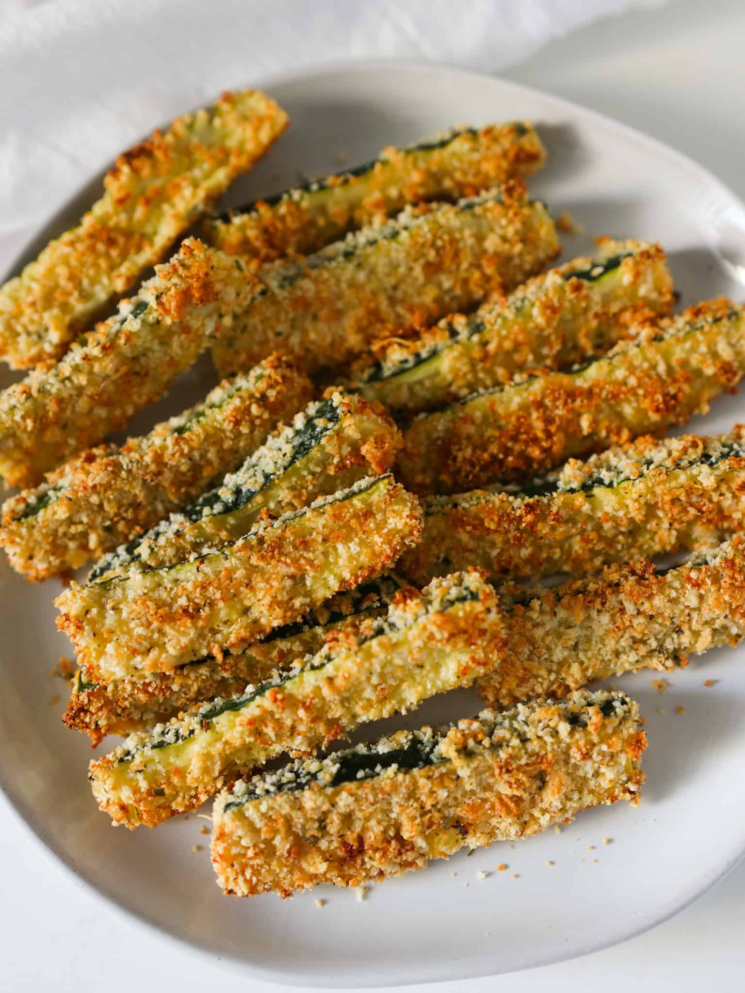 Crispy zucchini fries on a serving plate.