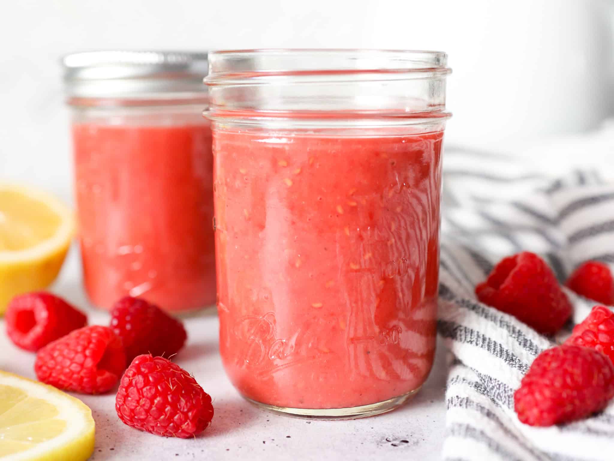 Close up front view of raspberry vinaigrette dressing in a mason jar.