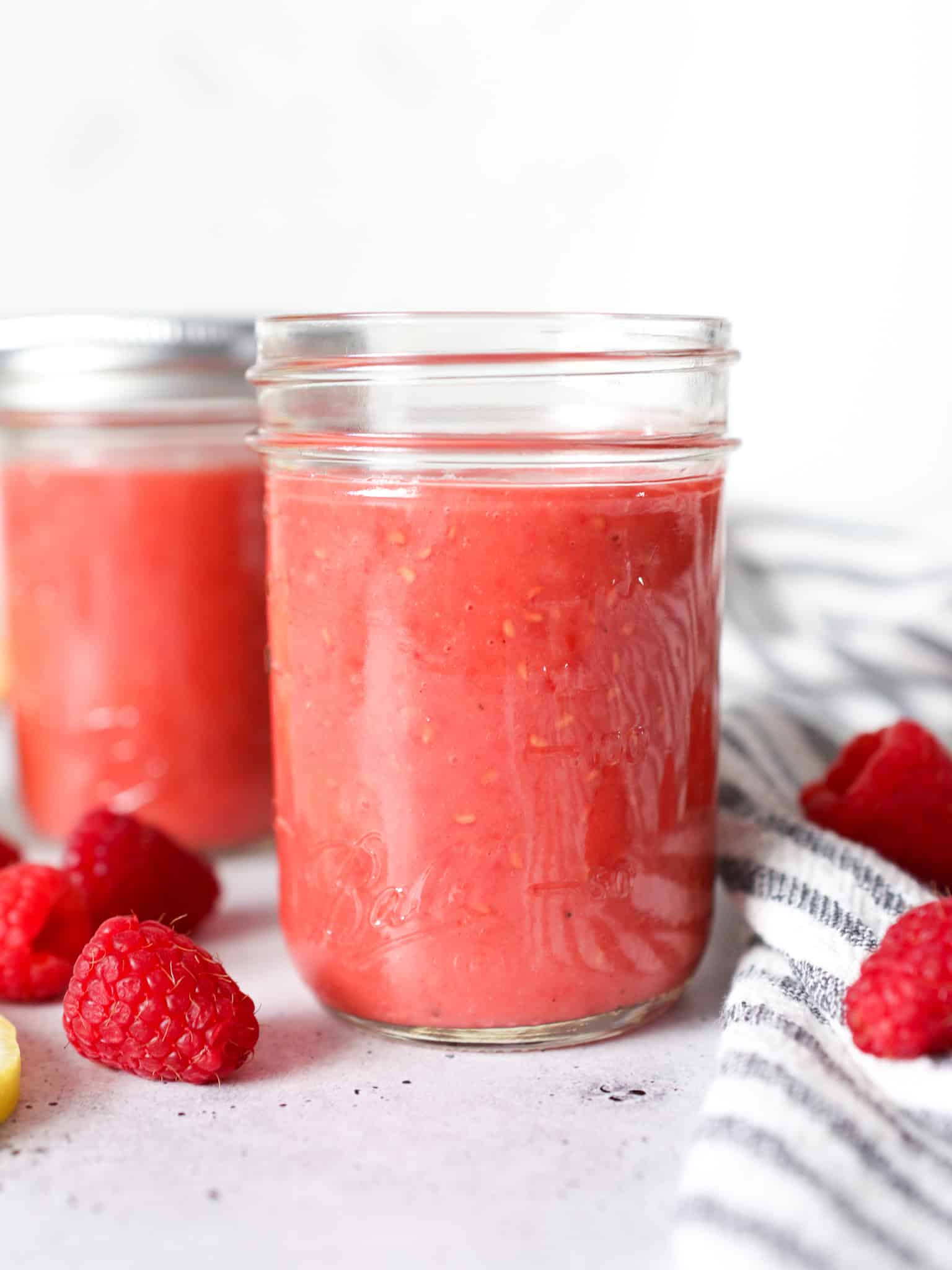 Close up front view of raspberry vinaigrette dressing in a mason jar.