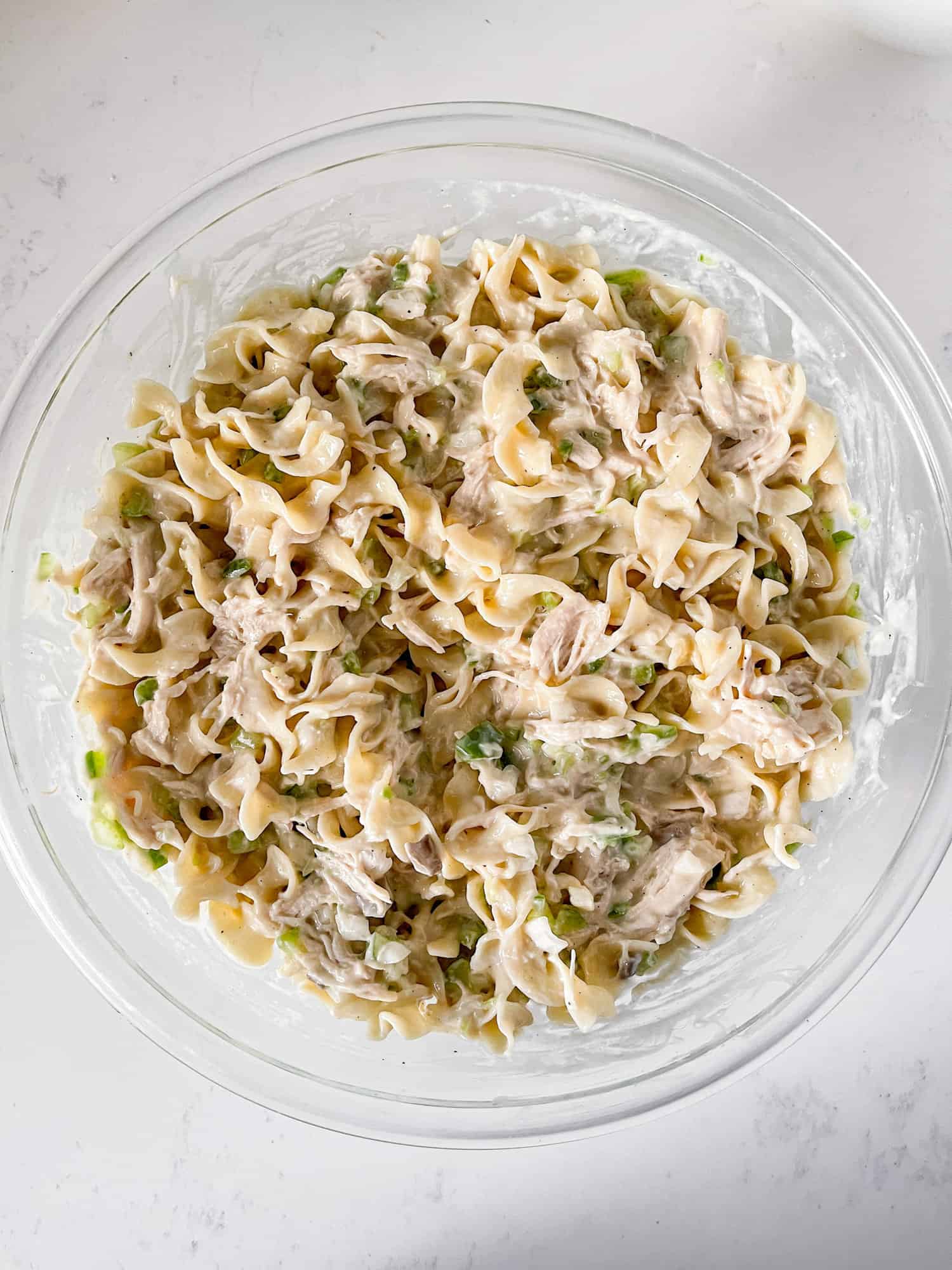 Chicken tetrazzini mixed in a large glass bowl