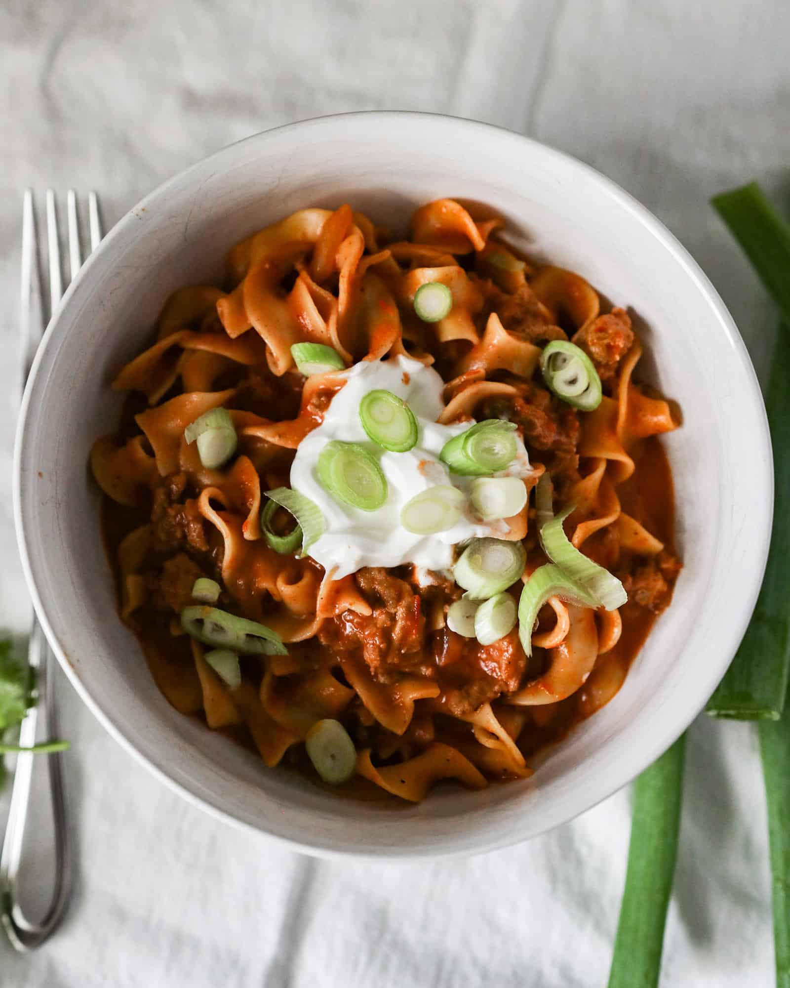 instant pot taco pasta in a white bowl with sour cream topping overhead shot in 