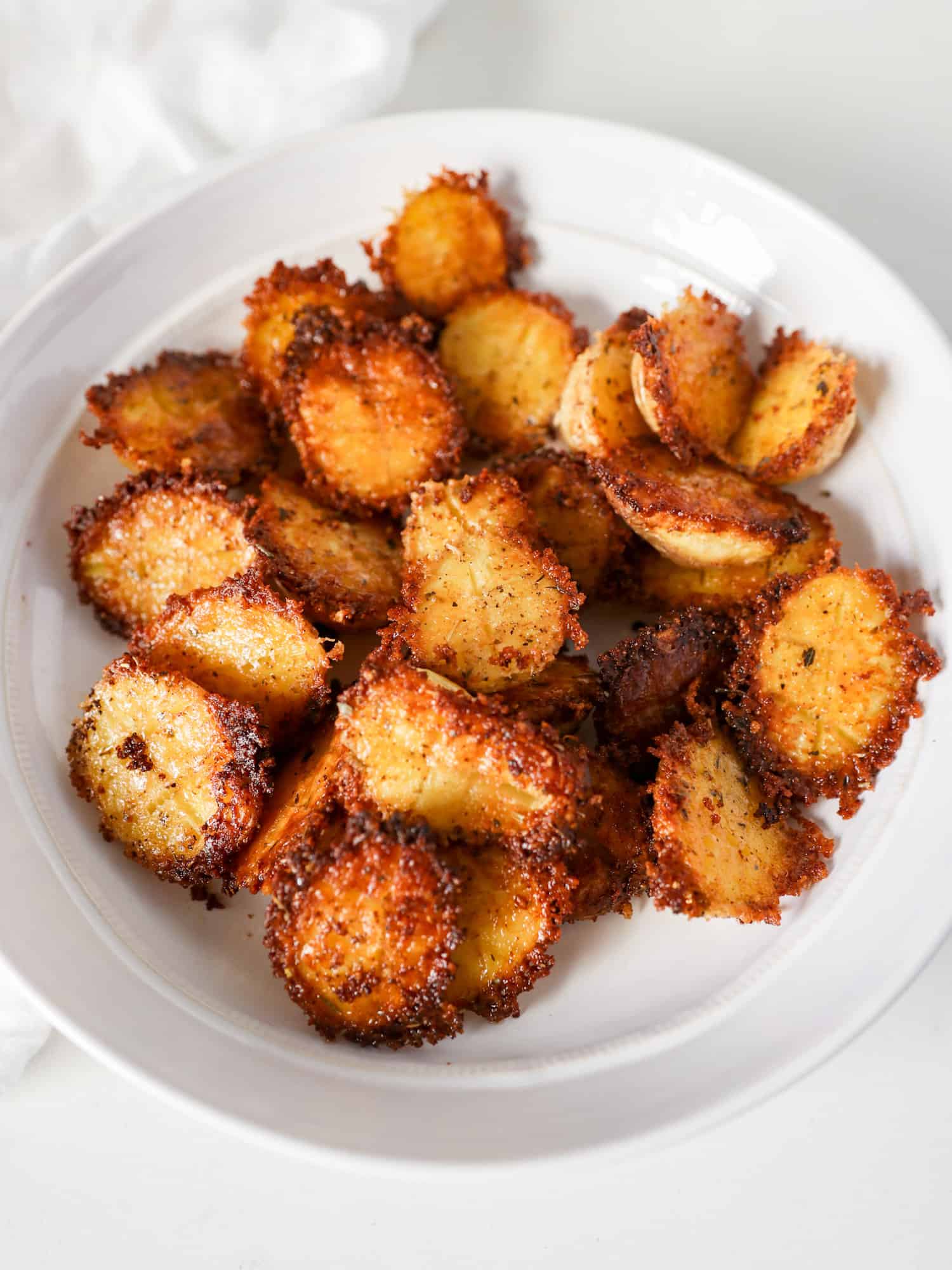Parmesan Crusted Potatoes in white bowl with white napkin