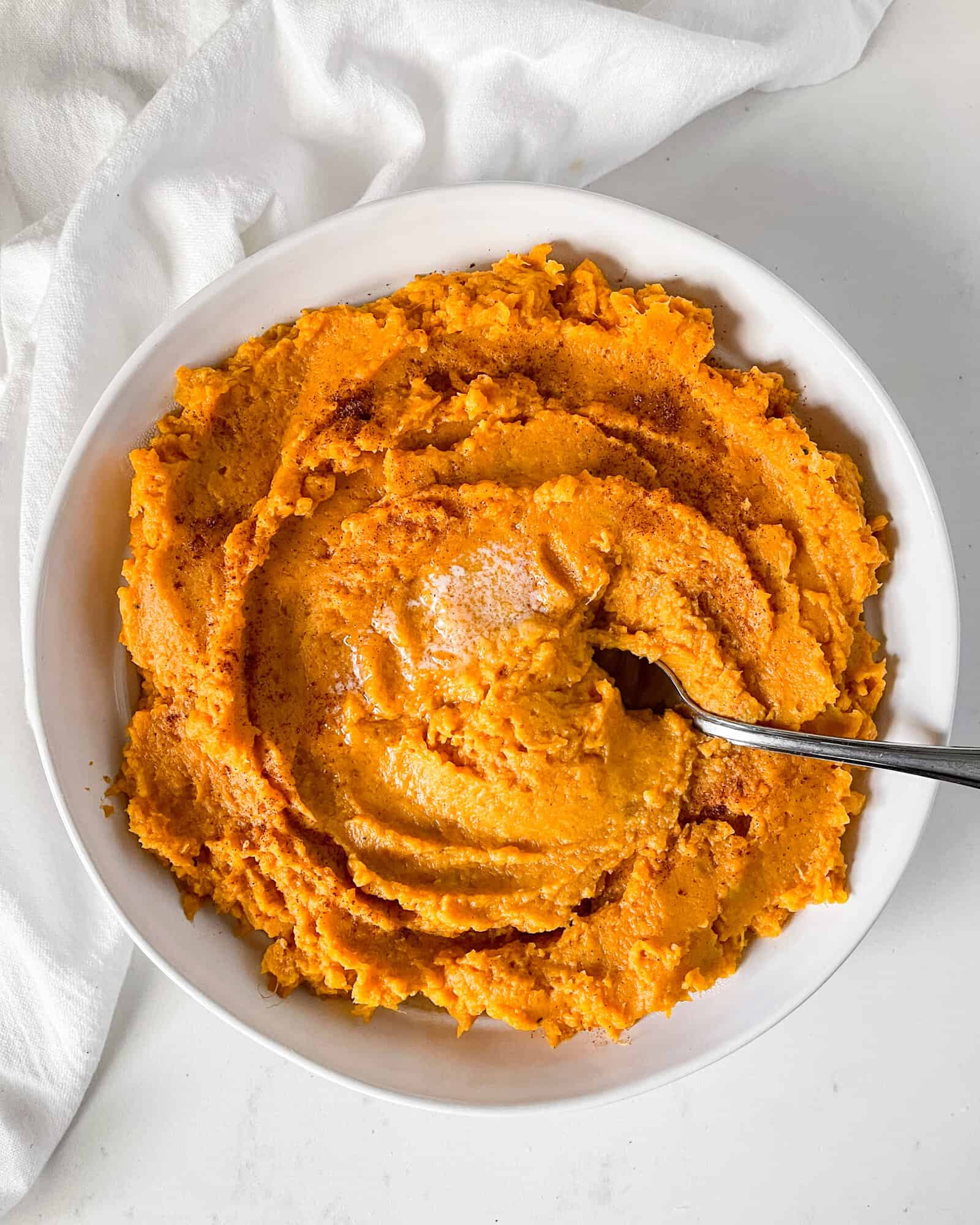 Brown Butter Mashed Sweet Potatoes in a white serving dish