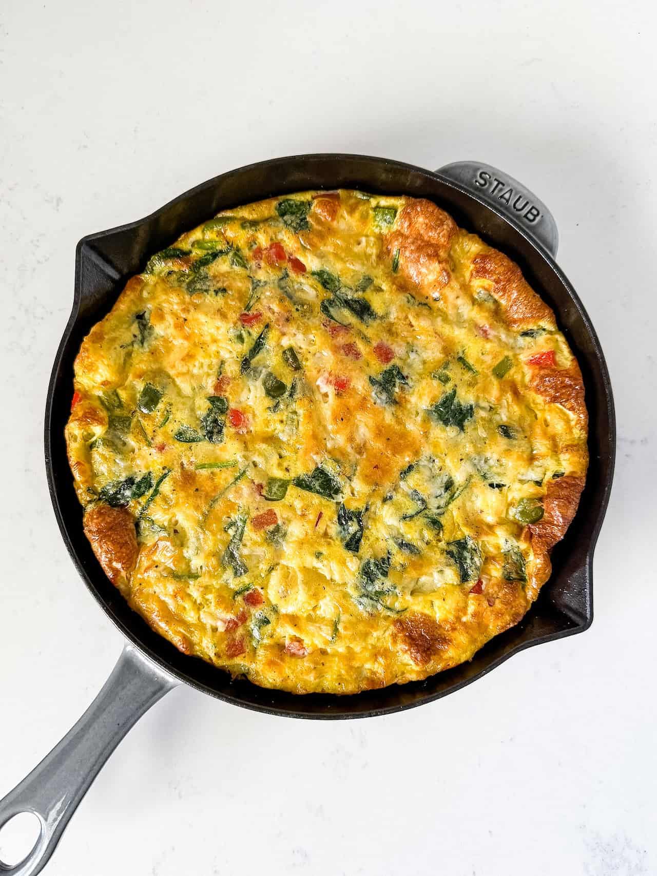 Overhead view of a cooked frittata in a skillet.
