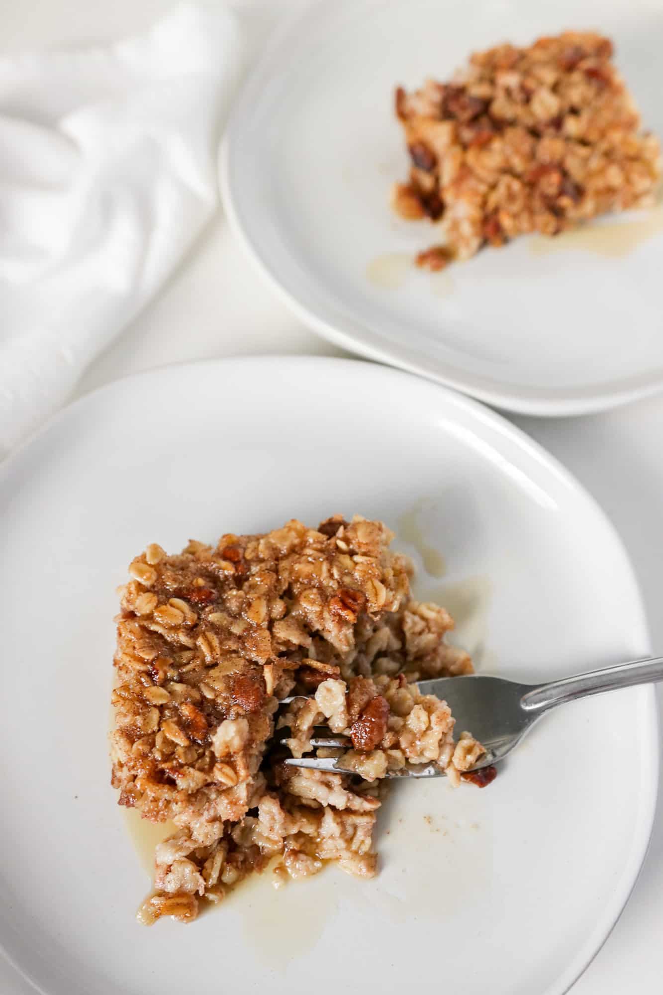 Baked Banana Oatmeal on a white plate with maple syrup