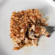 Baked Banana Nut Oatmeal on a white plate with maple syrup