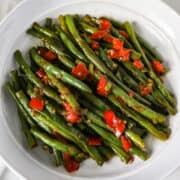 Skillet Sauteed Green beans with peppers and onions in a white serving bowl