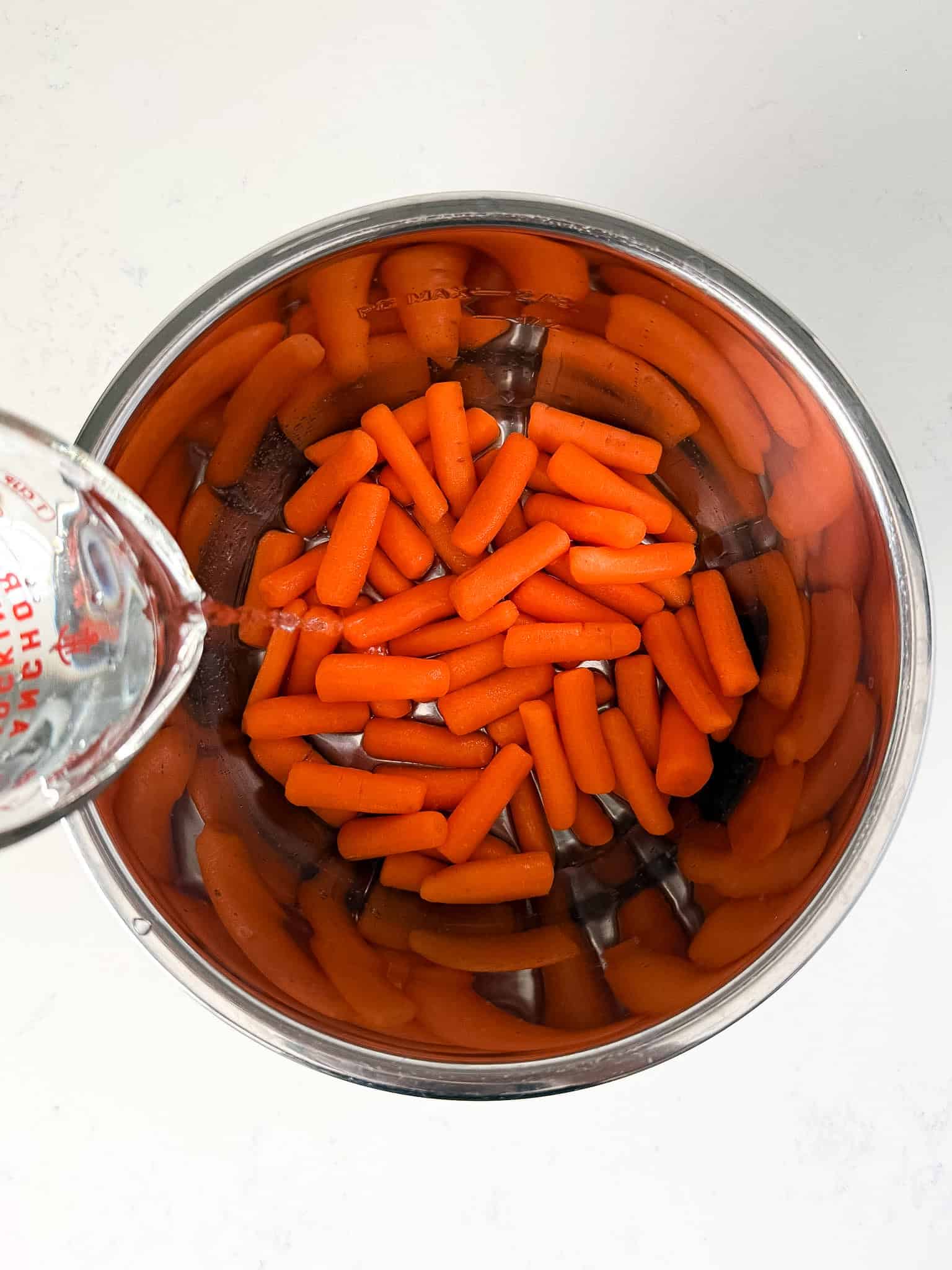 Water being added to carrots in the instant pot.