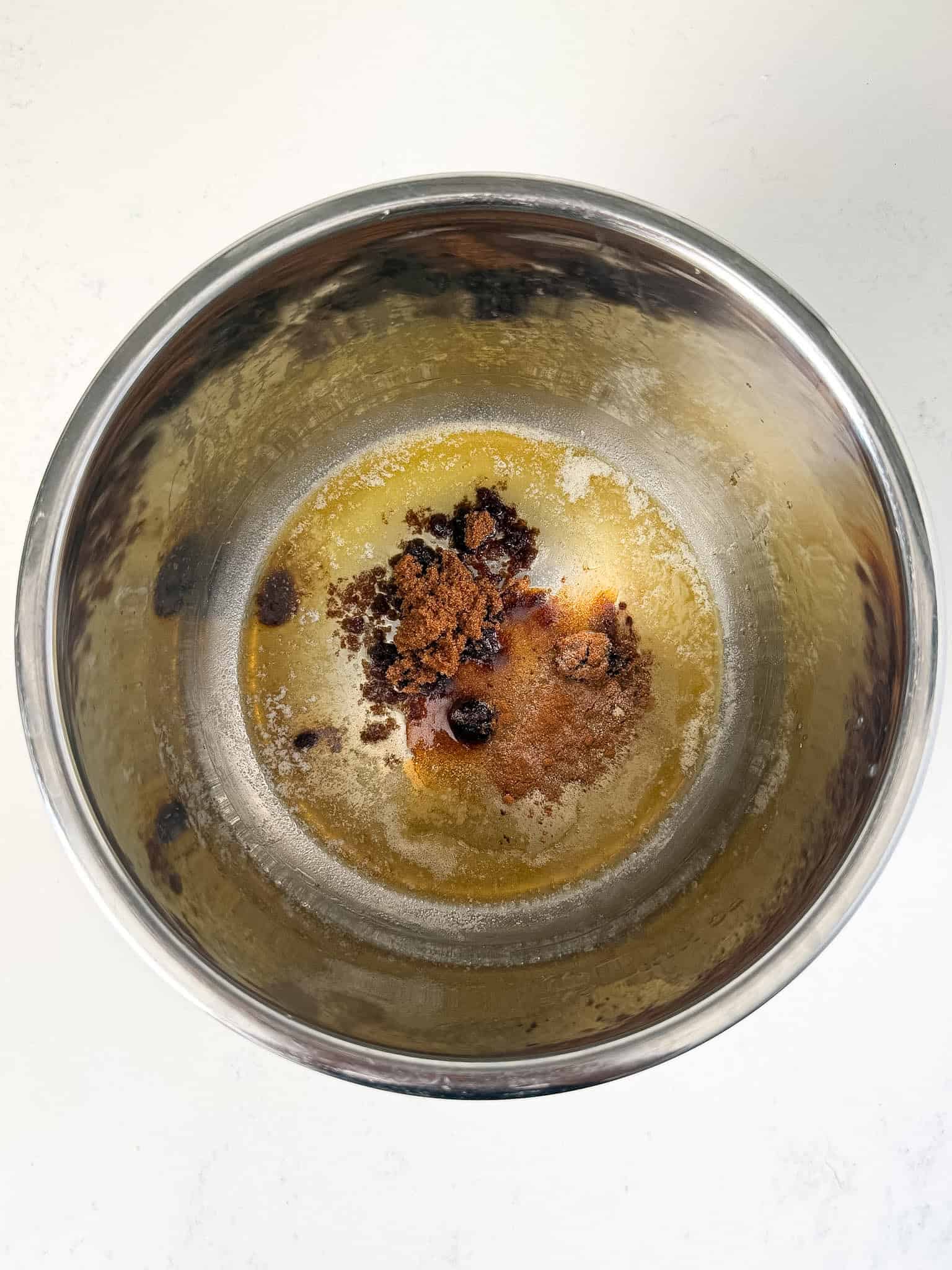 Butter, brown sugar, and maple syrup being melted in the instant pot.