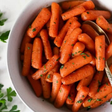 Overhead view of glazed instant pot carrots in a white serving dish.