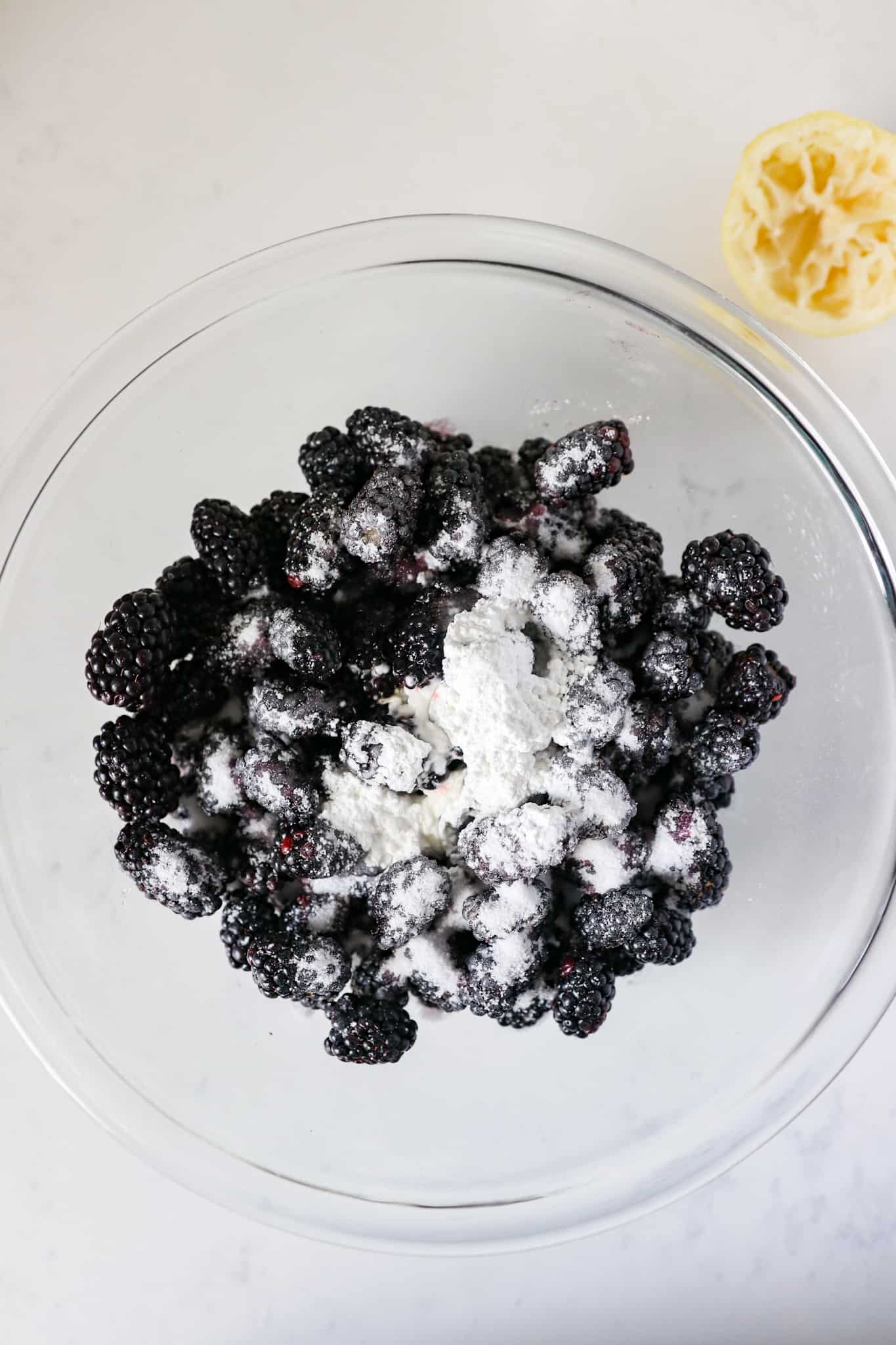 Blackberries in a bowl with cornstarch, sugar and lemon juice.