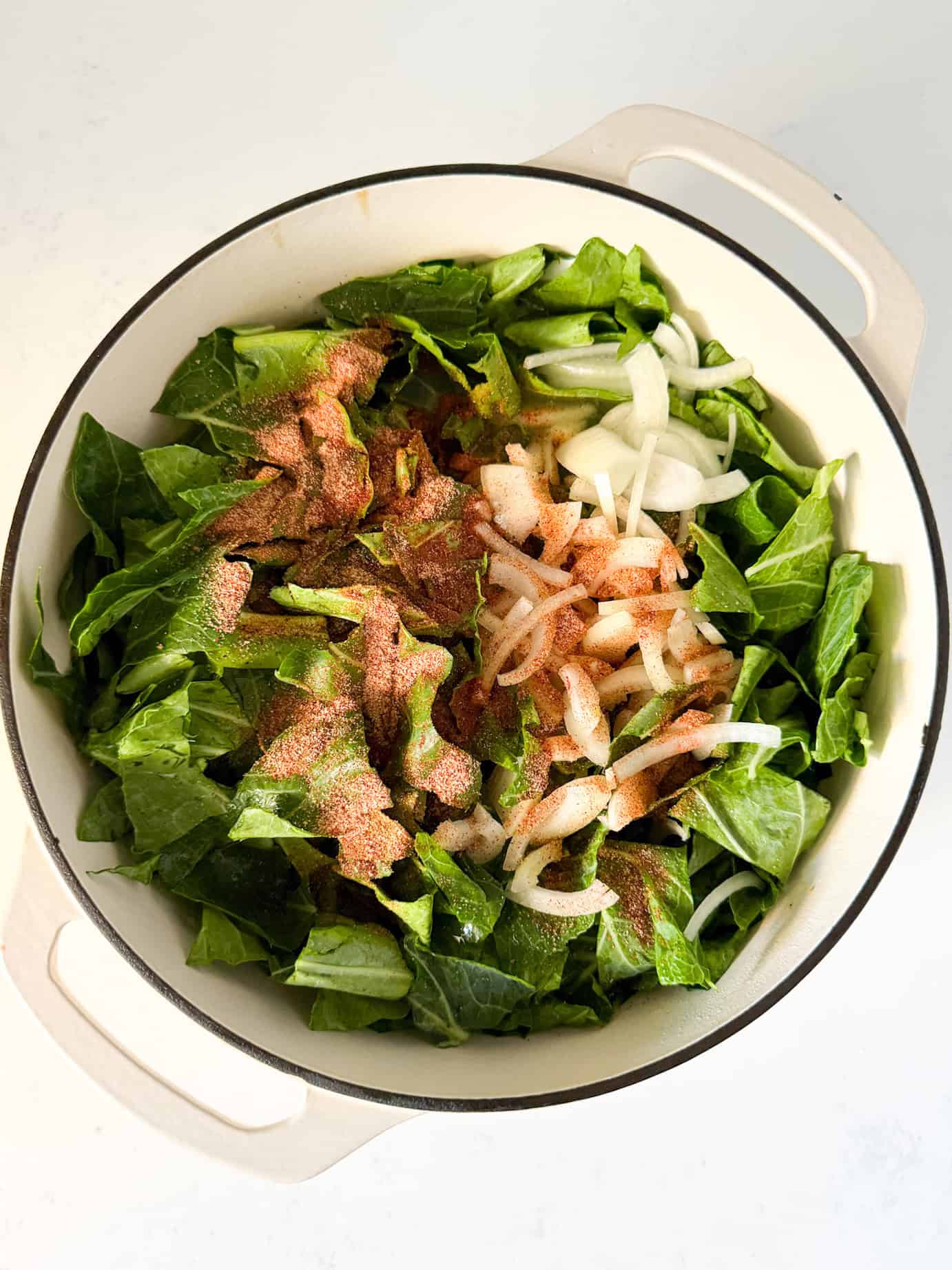 Collard greens added to dutch oven pot.