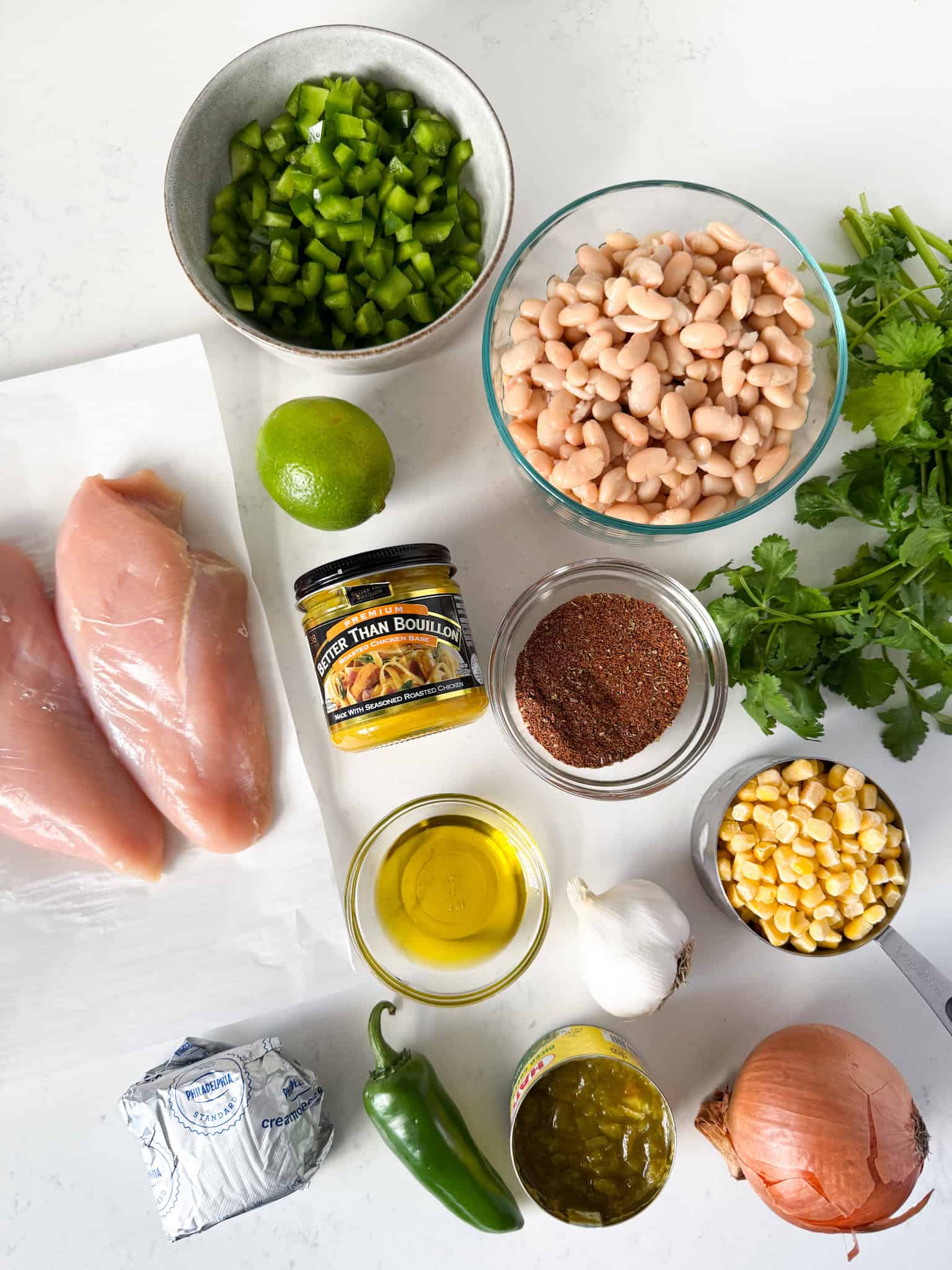 Overhead view of ingredients for white chicken chili on a white countertop.