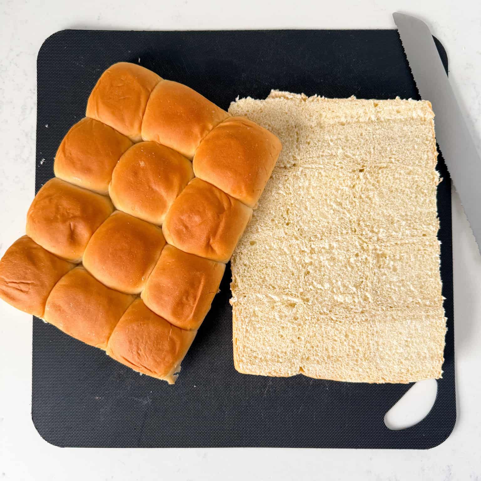 Hawaiian rolls cut in half on a cutting board
