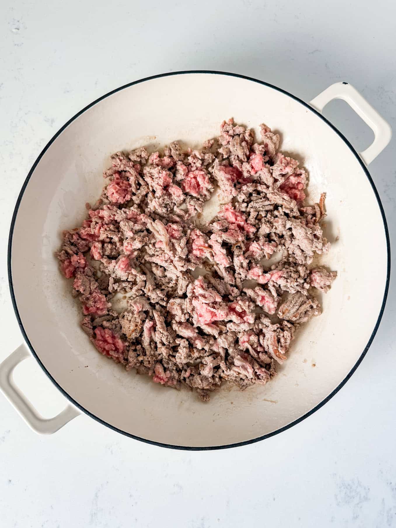 Ground turkey being cooked in a skillet.