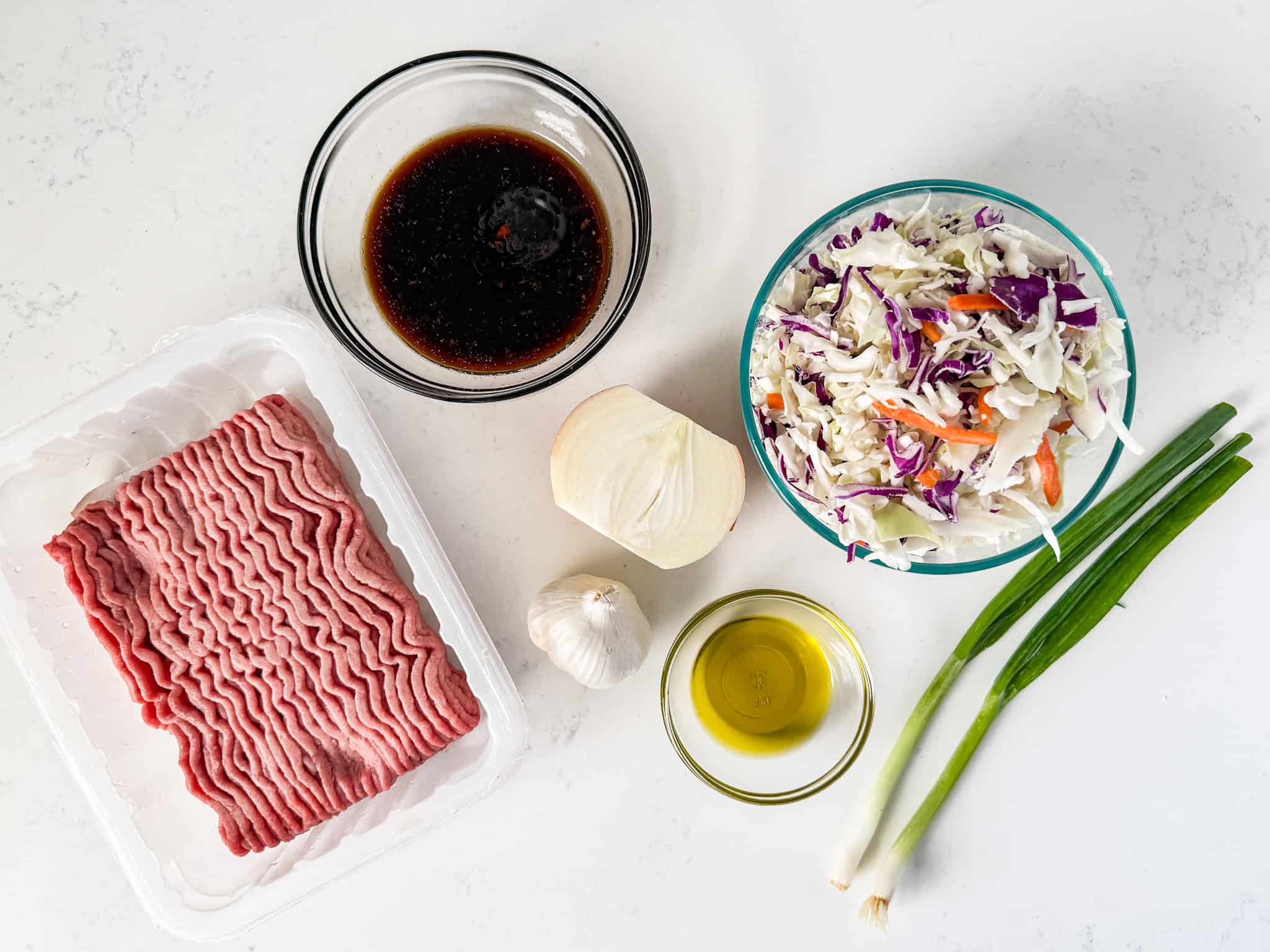 Ingredients for Egg roll in a bowl spread out on a white countertop.