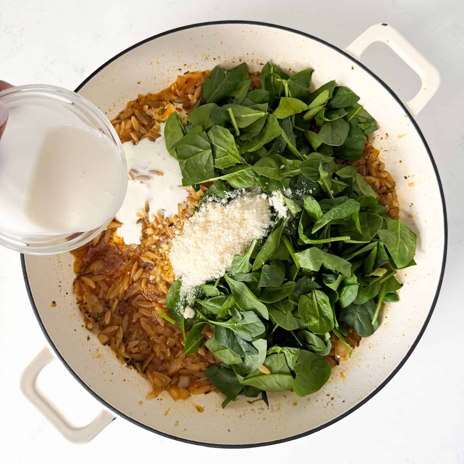 Spinach, parmesan, and heavy cream added to skillet.