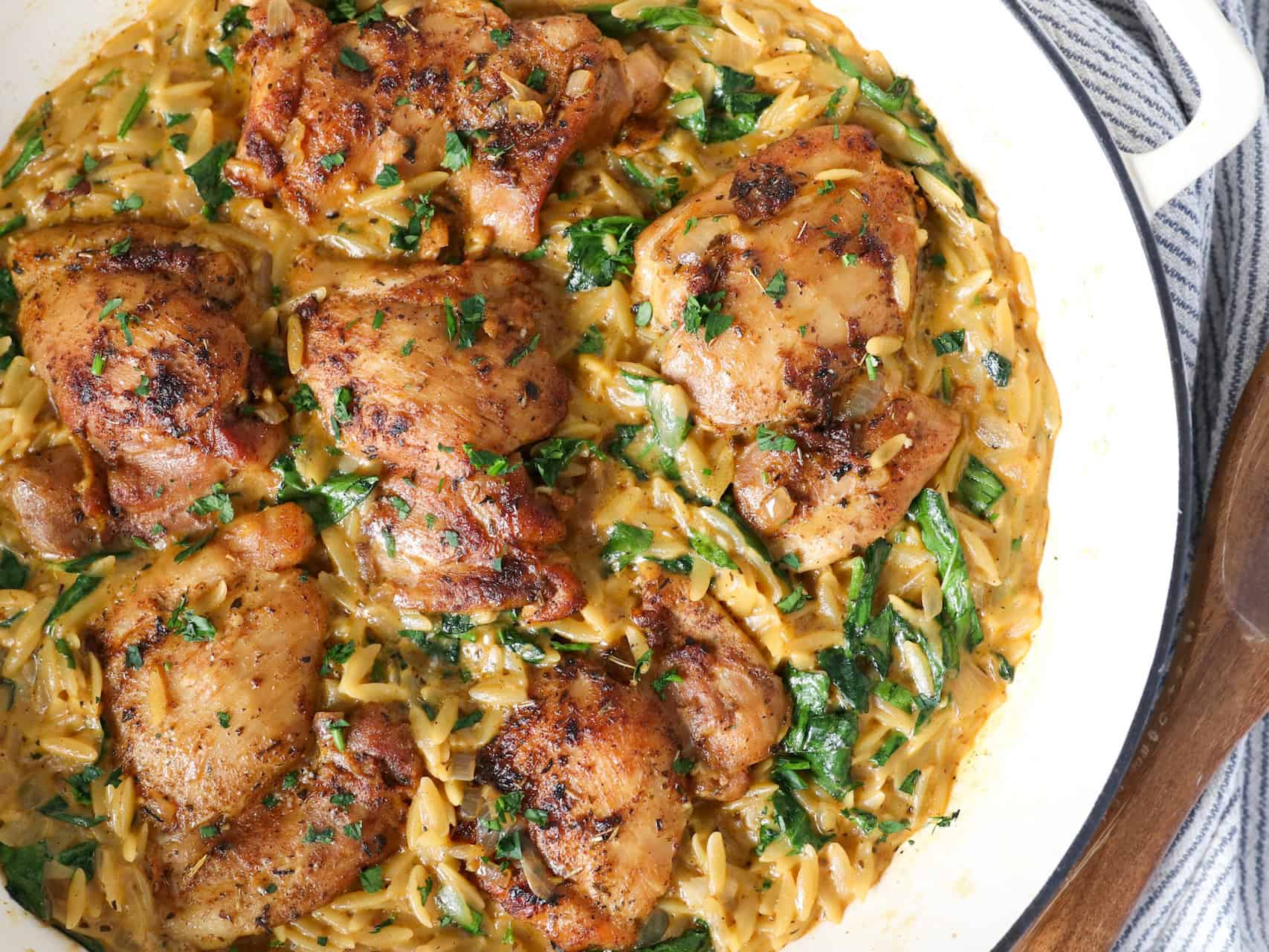 Overhead view of one pan chicken and orzo pasta in a cast iron skillet.