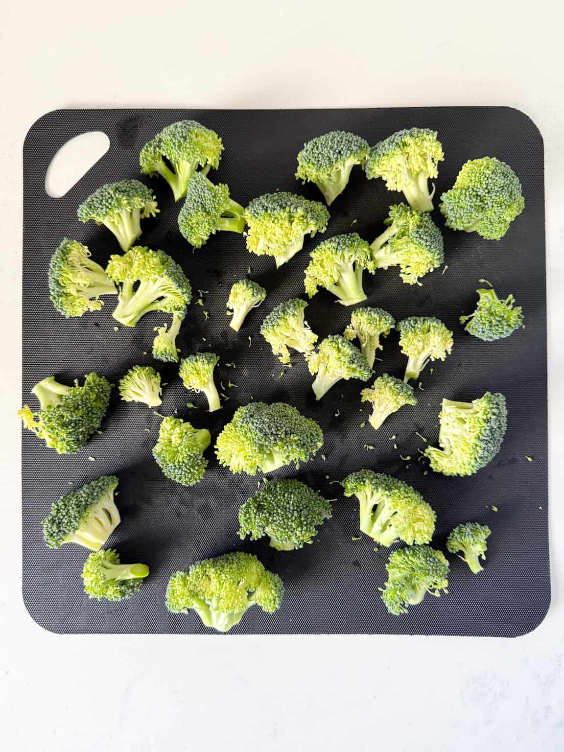 Broccoli florets on a cutting board.