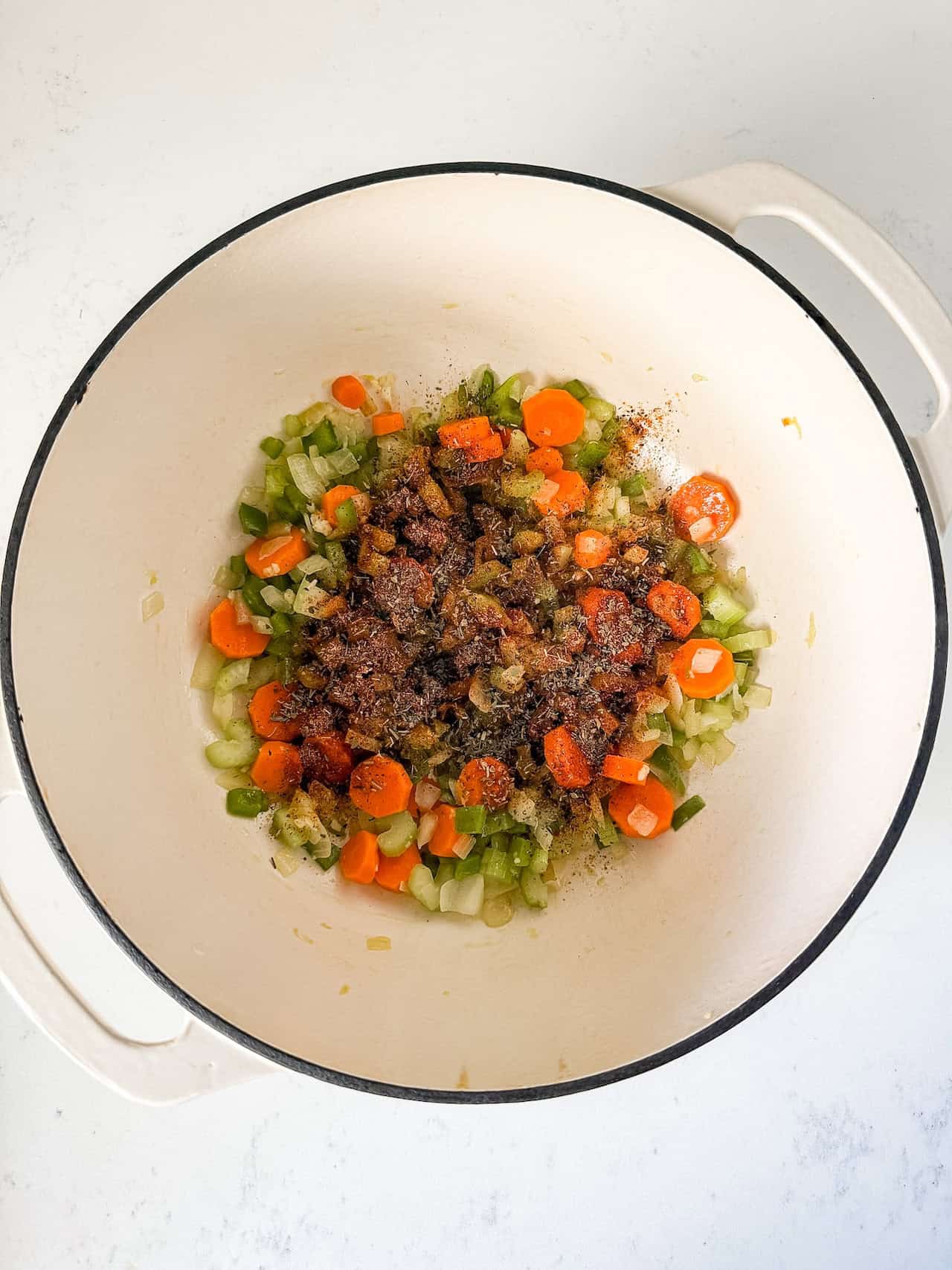 Spices added to sautéed vegetables in dutch oven pot.