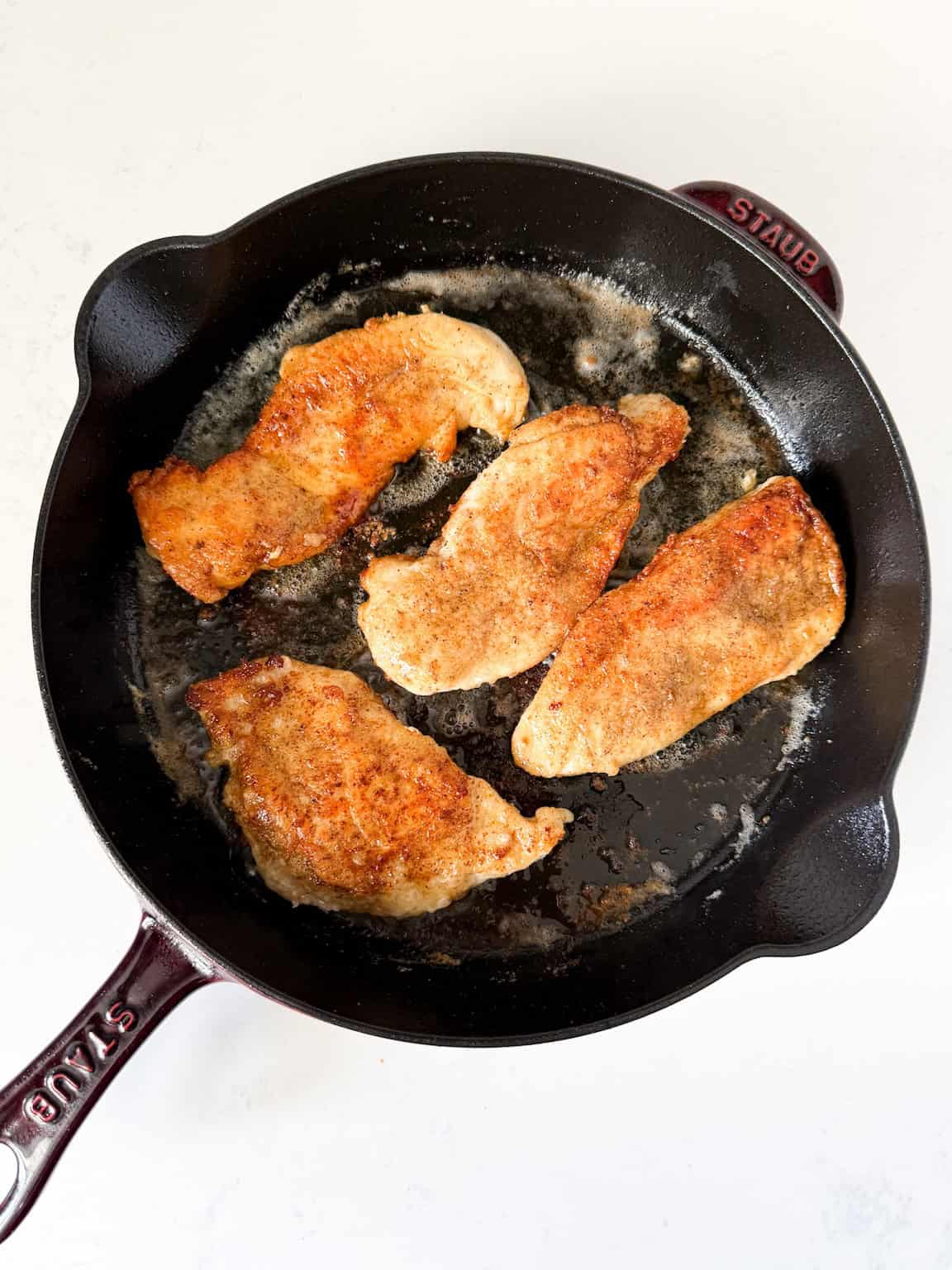 pan-fried chicken breasts in a cast iron skillet.