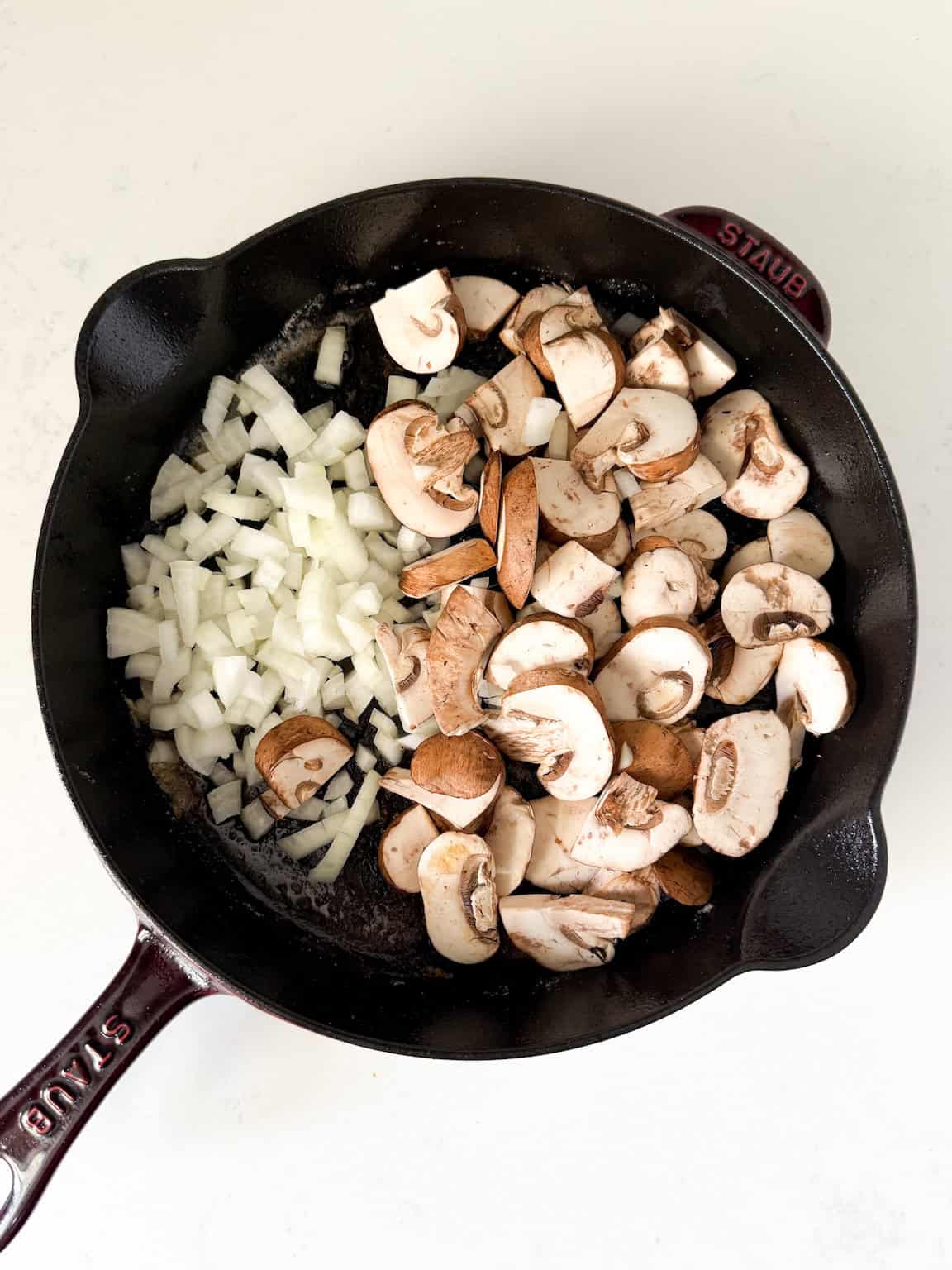 Sautéed onions and mushrooms in a cast-iron skillet.