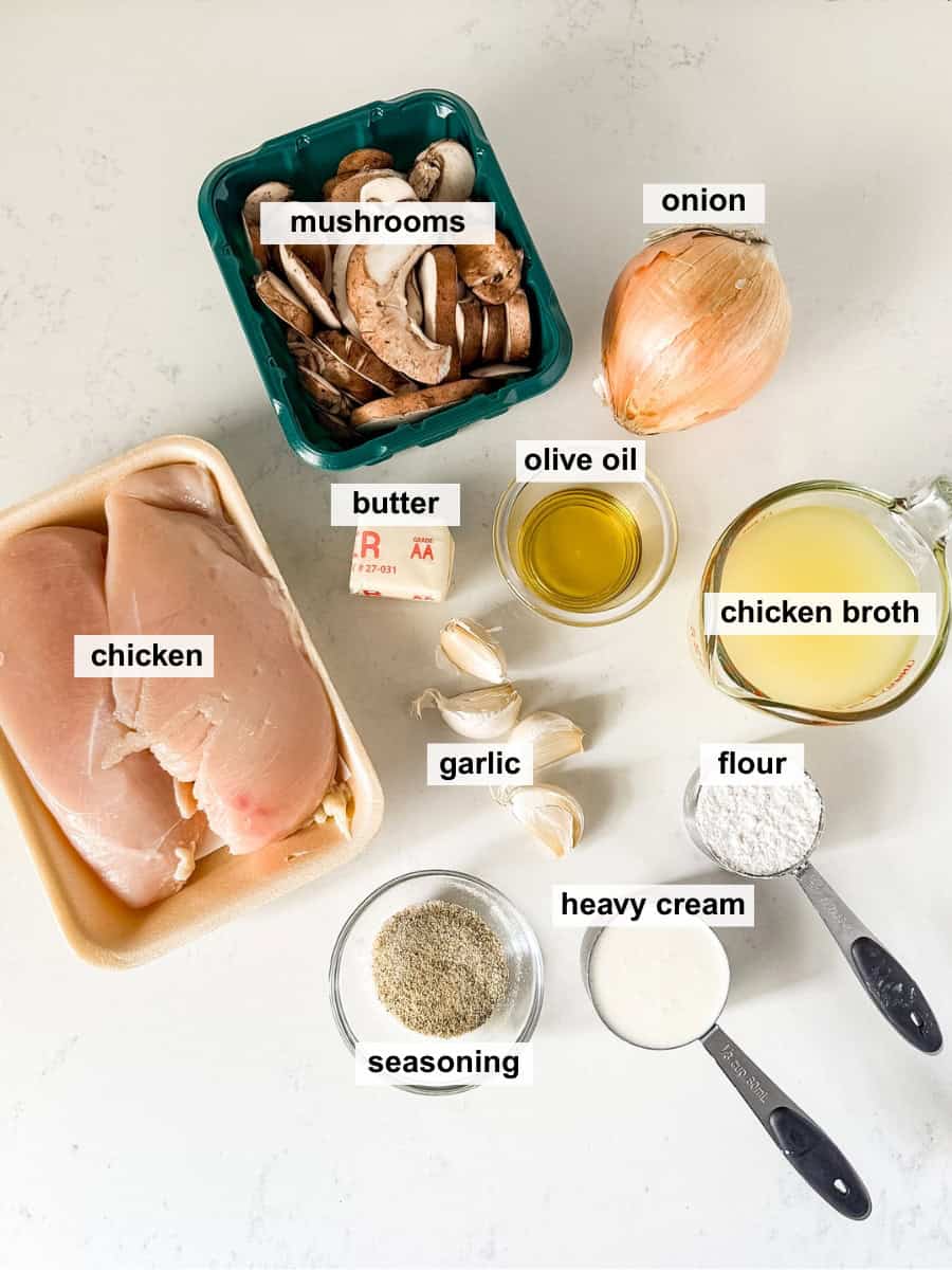 Ingredients for creamy mushroom chicken spread out on a white countertop.