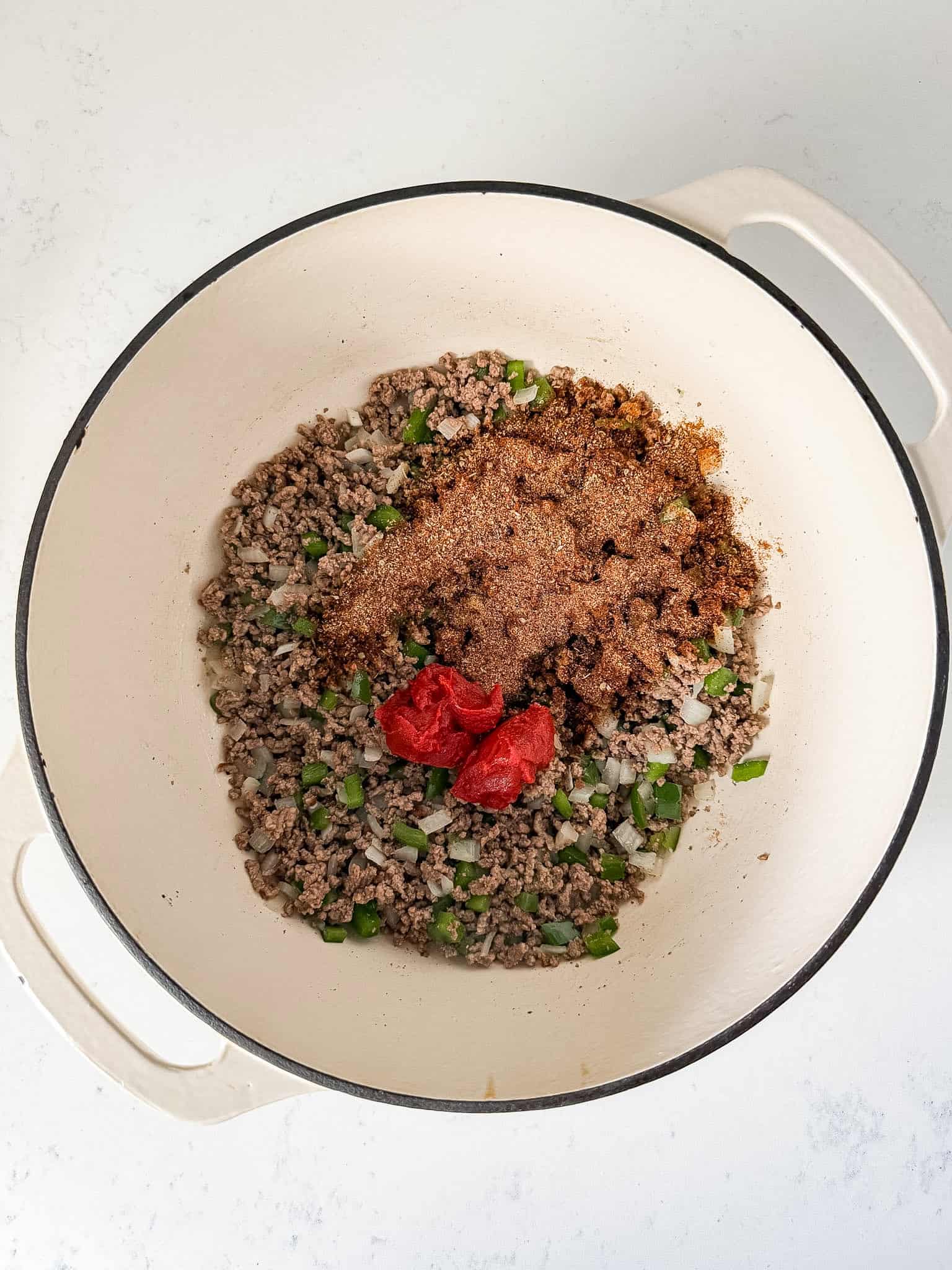 Tomato paste and taco seasoning added to the pot.