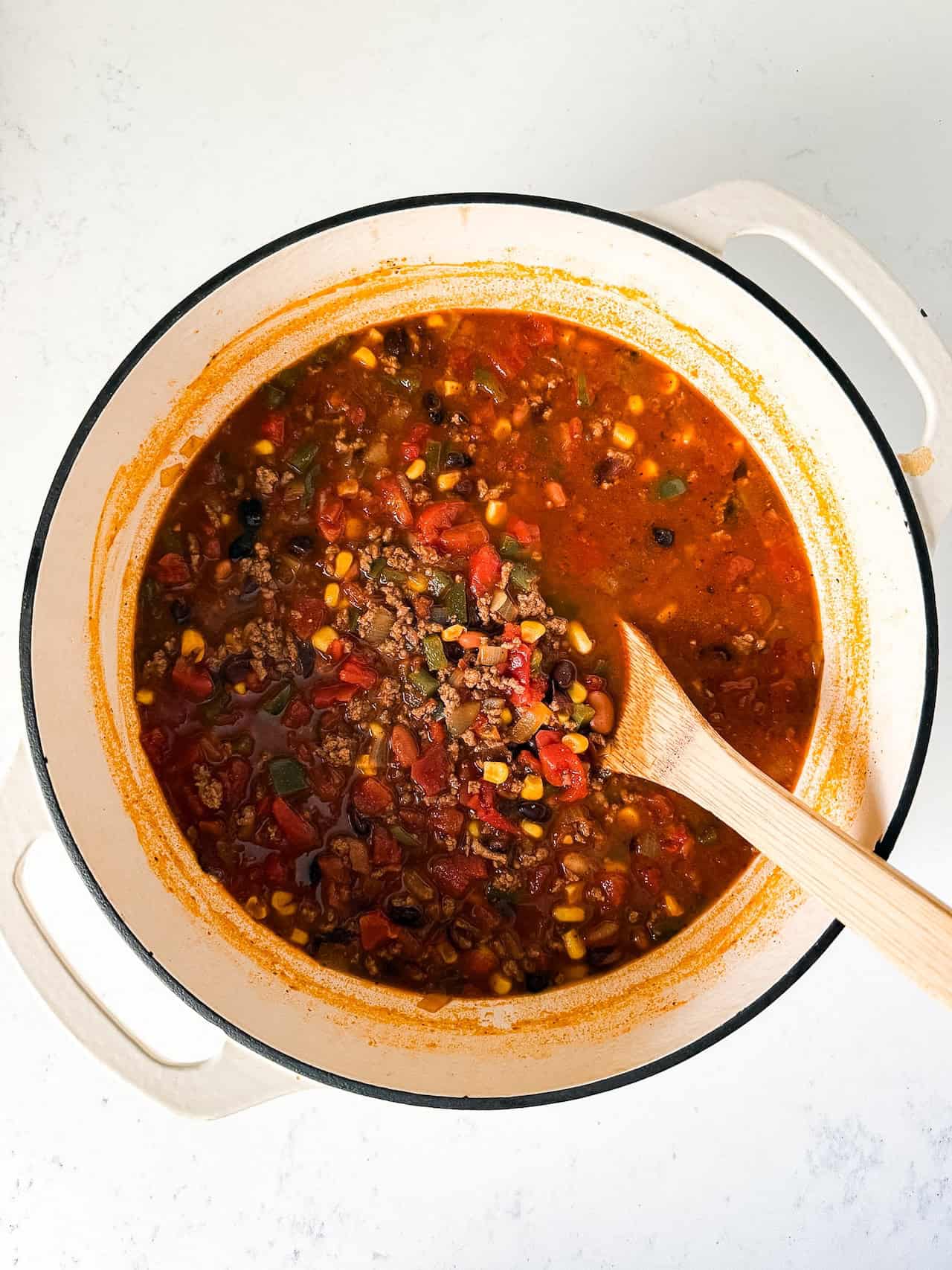Cooked taco soup in a white dutch oven pot.
