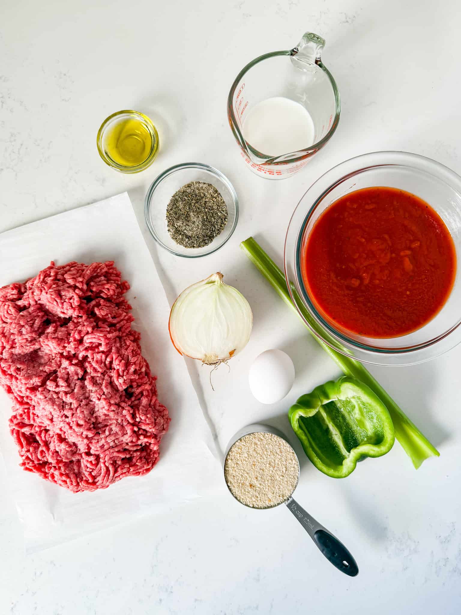 Ingredients for meatloaf recipe on a white countertop.