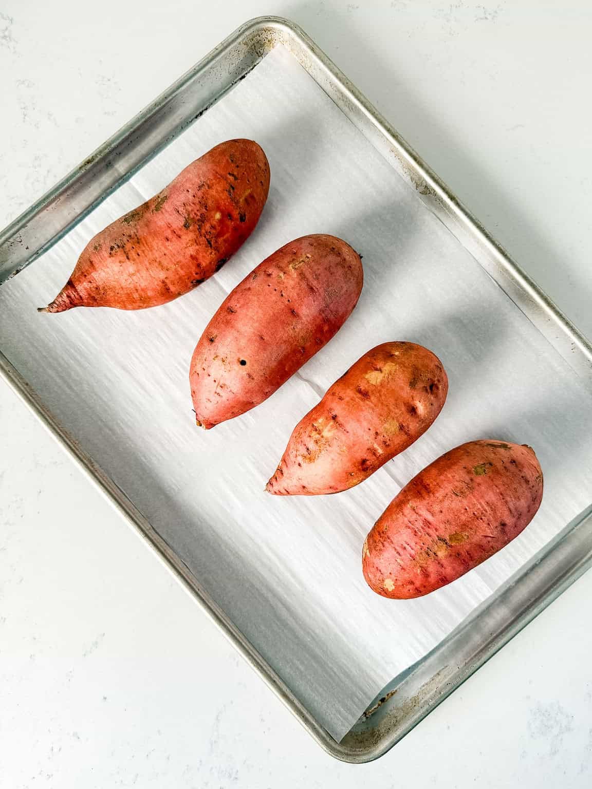 Sweet potatoes placed on a baking sheet