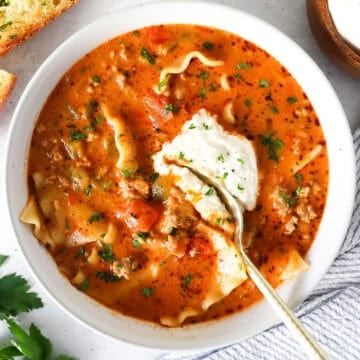 Overhead view of lasagna soup in a bowl with a spoon scooping some out.